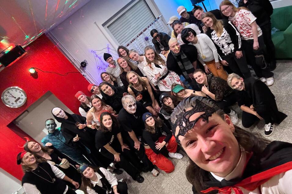 Gruppenselfie auf einer Mottoparty mit verkleideten Gästen, die in bunten Kostümen und Masken posieren.