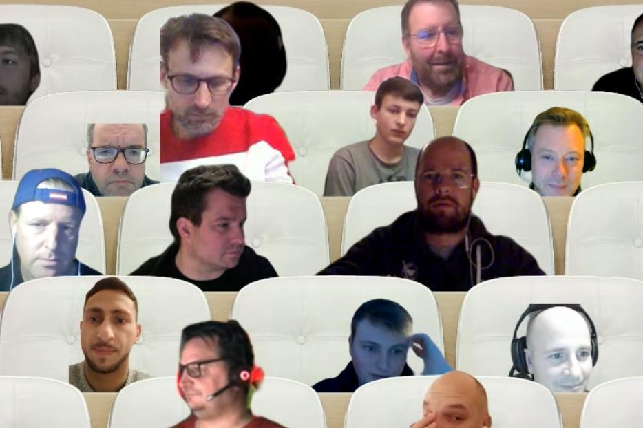 Virtuelle Besprechung mit mehreren Teilnehmern in einem digitalen Raum, die auf wei&szlig;en St&uuml;hlen sitzen.