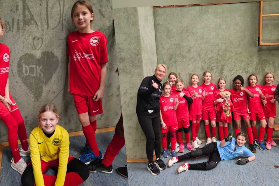 M&auml;dchen-Fu&szlig;ballmannschaft in roten Trikots posiert auf einer Sportfl&auml;che, daneben ein graues Wandbild mit Herzen.