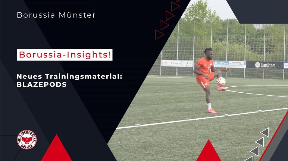 Fu&szlig;ballspieler trainiert auf einem Sportplatz mit Blazepods. Im Hintergrund sind Spielfeldmarkierungen und Netze sichtbar.