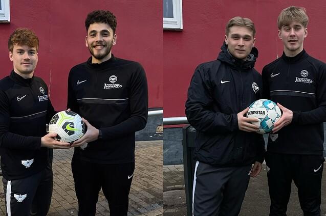 Zwei junge M&auml;nner in Sportkleidung halten jeweils einen Fu&szlig;ball vor einer roten Wand.