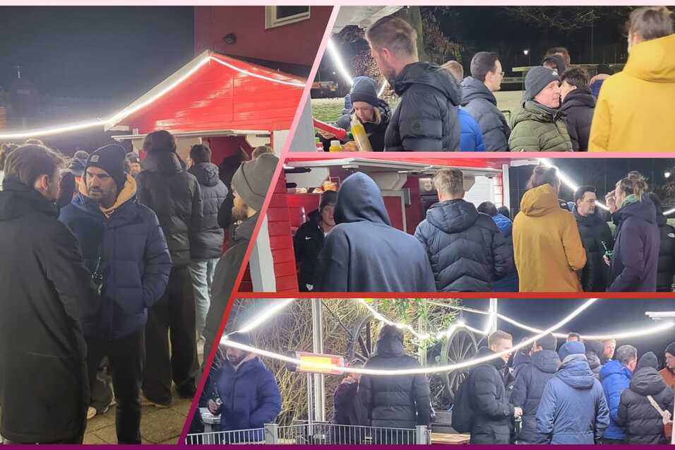Gruppengespr&auml;ch von Menschen in warmer Kleidung an einem festlich beleuchteten Stand im Freien bei Nacht.