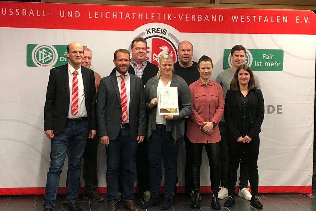 Gruppe von sieben Personen steht vor einem Banner des Fu&szlig;ball- und Leichtathletik-Verbandes Westfalen e.V. mit Auszeichnung.