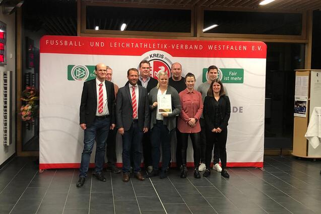 Gruppe von sieben Personen steht vor einem Banner des Fu&szlig;ball- und Leichtathletik-Verbandes Westfalen e.V. mit Auszeichnung.