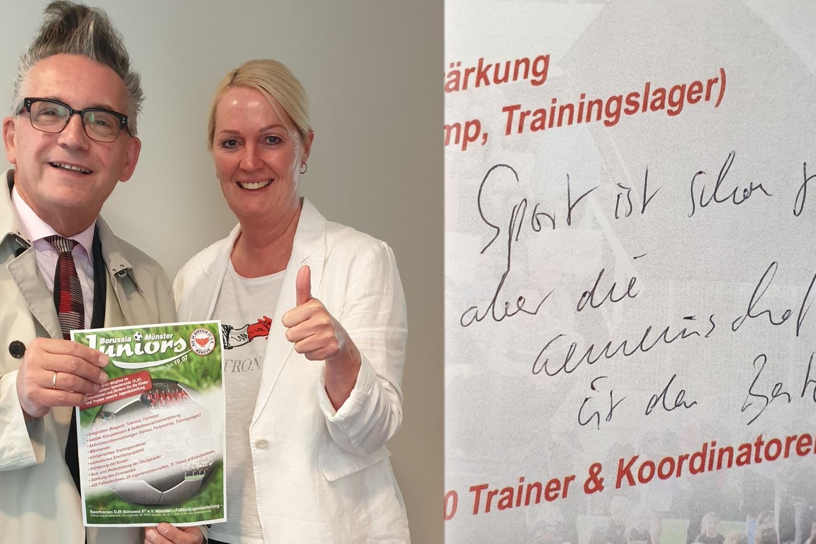Zwei Personen posieren l&auml;chelnd mit einem Trainingslager-Flyer, daneben ein handschriftlicher Text auf Papier.