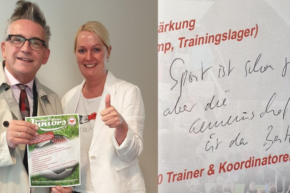Zwei Personen posieren l&auml;chelnd mit einem Trainingslager-Flyer, daneben ein handschriftlicher Text auf Papier.