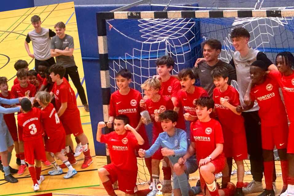Gruppenshooting einer Fu&szlig;balljugendmannschaft in roten Trikots, l&auml;chelnd und posierend vor dem Tor.