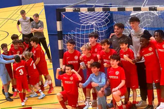 Gruppenshooting einer Fu&szlig;balljugendmannschaft in roten Trikots, l&auml;chelnd und posierend vor dem Tor.