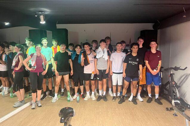 Gruppe von Jugendlichen in Sportkleidung posiert in einem Fitnessraum nach dem Training.