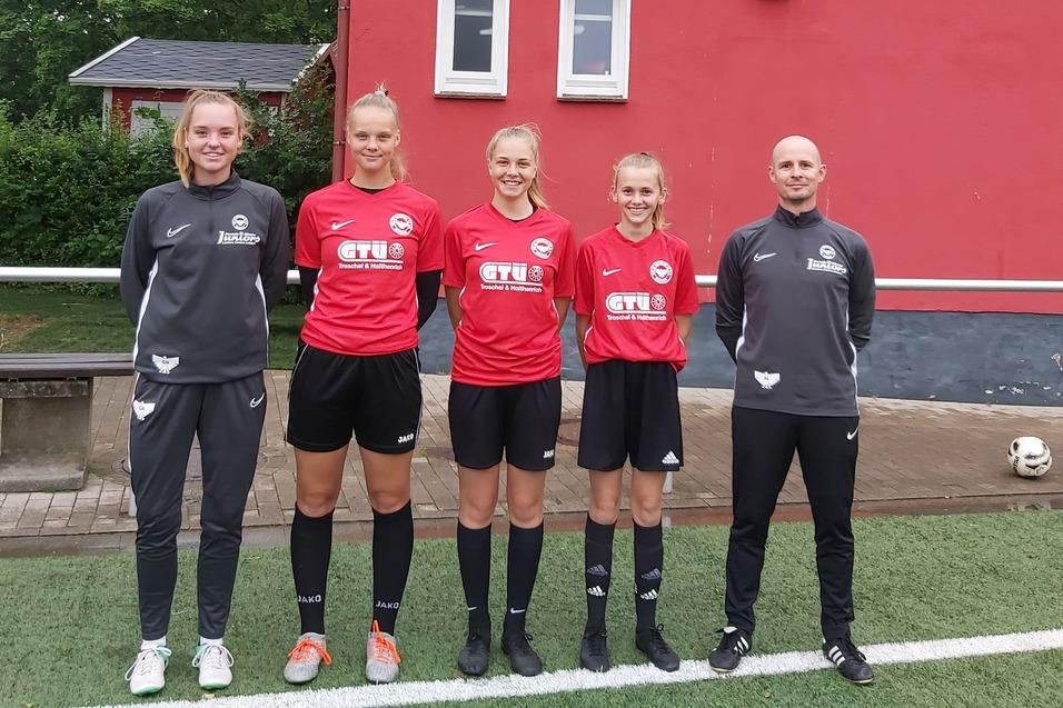 F&uuml;nf Fu&szlig;ballspielerinnen in roten Trikots stehen vor einem Vereinsgeb&auml;ude mit Logo des SV Borussia M&uuml;nster.