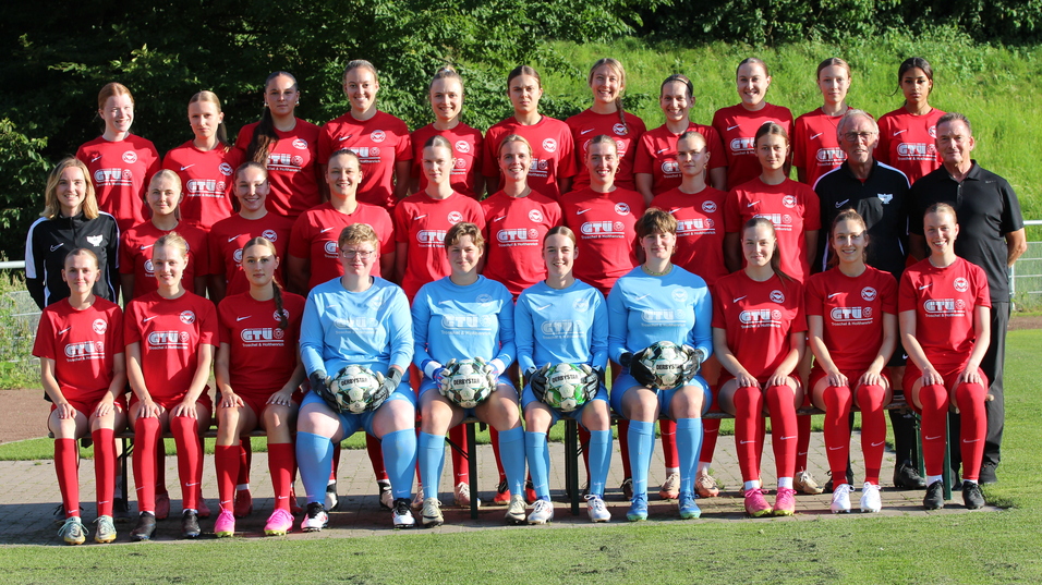 Mannschaftsfoto einer Fu&szlig;ballmannschaft mit 24 Spielerinnen in roten Trikots und zwei Torh&uuml;terinnen in blauen Trikots.