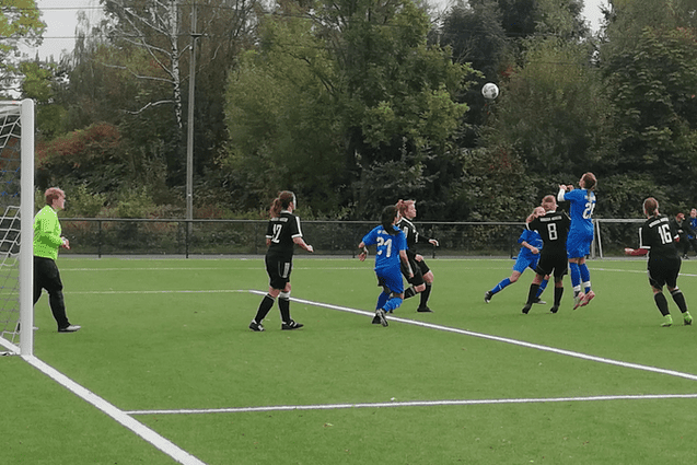 Frauenfu&szlig;ballspiel: Spielerinnen in schwarzen und blauen Trikots springen zum Kopfball auf einem Kunstrasenplatz.