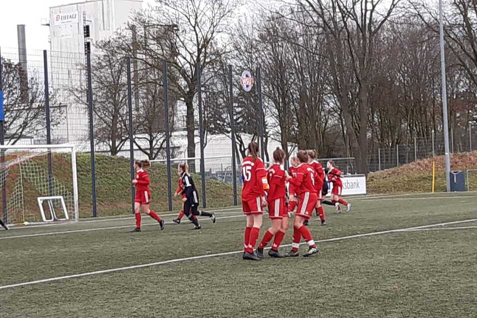 Spielszene mit einer Freisto&szlig;situation, ein Torwart in Schwarz steht im Tor, Spieler in Rot bilden eine Mauer.