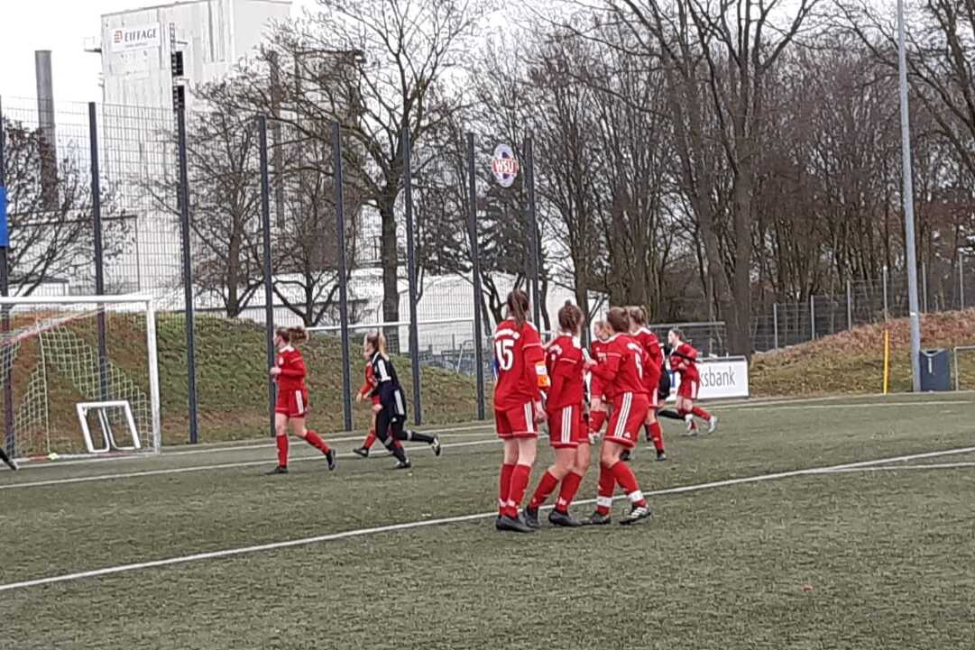 Spielszene mit einer Freisto&szlig;situation, ein Torwart in Schwarz steht im Tor, Spieler in Rot bilden eine Mauer.