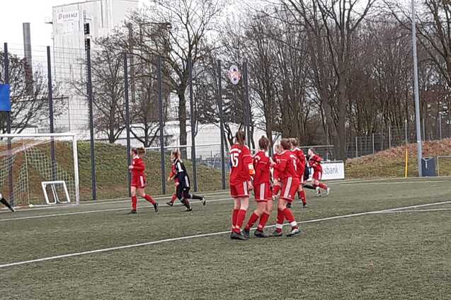 Spielszene mit einer Freisto&szlig;situation, ein Torwart in Schwarz steht im Tor, Spieler in Rot bilden eine Mauer.