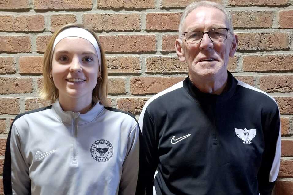 Zwei Personen stehen vor einer Ziegelwand: eine junge Frau in Sportkleidung und ein &auml;lterer Mann in Trainerjacke.