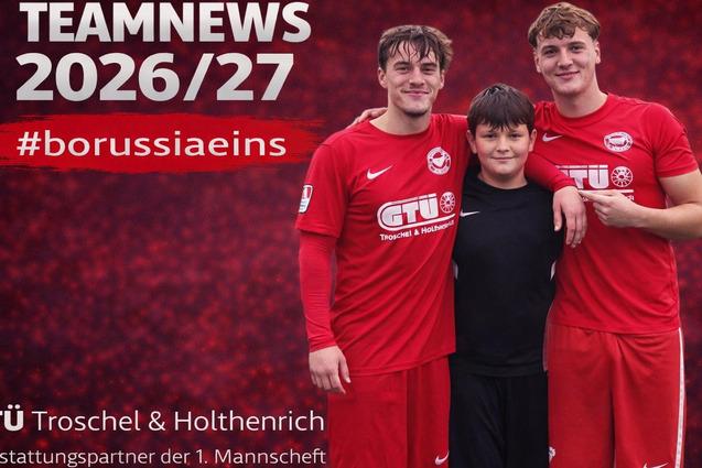 Drei Fu&szlig;ballspieler in roten Trikots posieren zusammen im Freien vor einem farbigen Hintergrund mit dem Schriftzug "TEAMNEWS 2026/27".