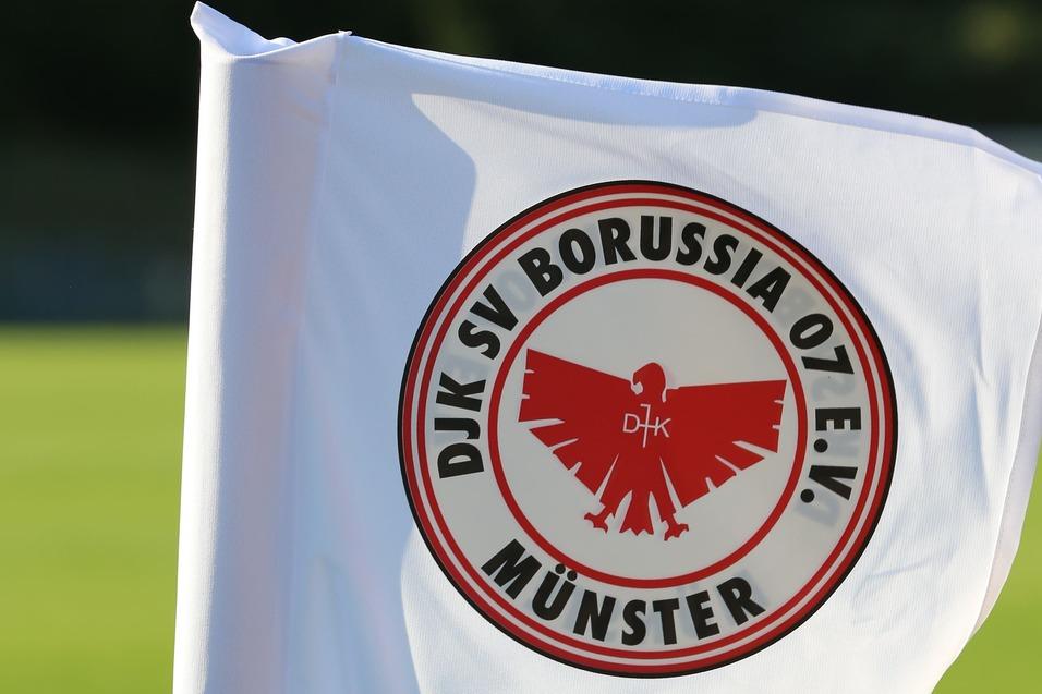 Wei&szlig;e Eckfahne mit dem Logo von DJK SV Borussia O2 e.V. M&uuml;nster auf einem Fu&szlig;ballfeld.