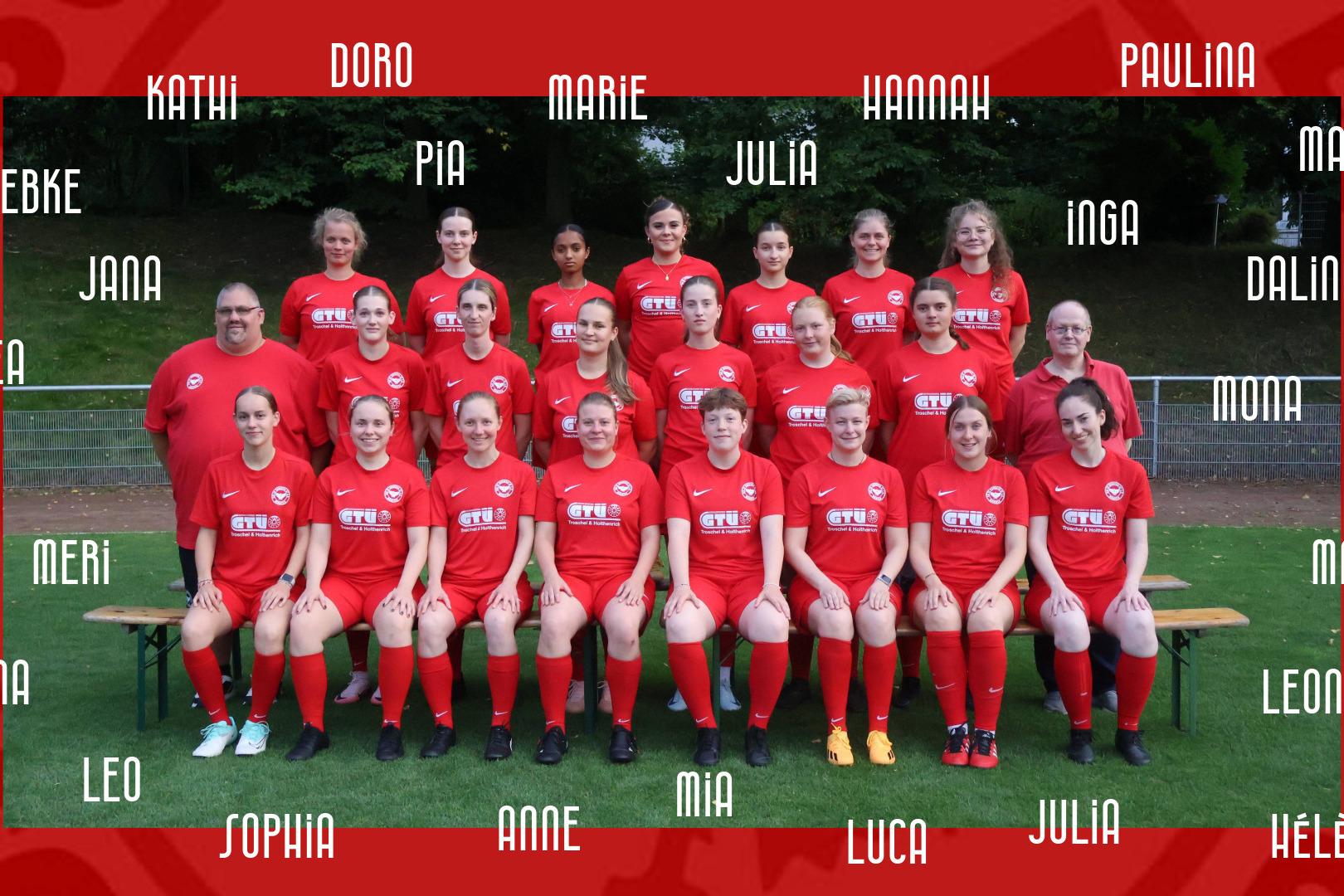 Gruppenfoto eines Frauenfu&szlig;ballteams in roten Trikots auf einem Sportplatz, mit Spielern in mehreren Reihen stehend und sitzend.