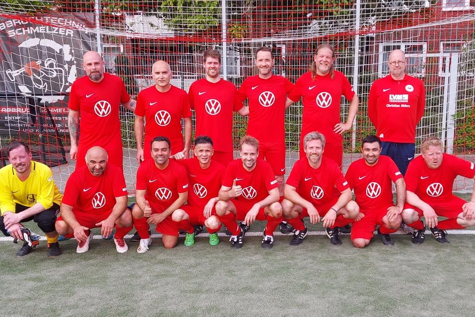 Gruppenfoto von elf Fu&szlig;ballspielern in roten Trikots vor einem Tor. Ein Torwart in Gelb sitzt vorne.