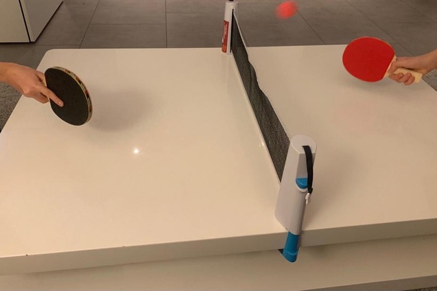 Zwei H&auml;nde mit Tischtennisschl&auml;gern spielen am Tisch, der Ball fliegt &uuml;ber das Netz.
