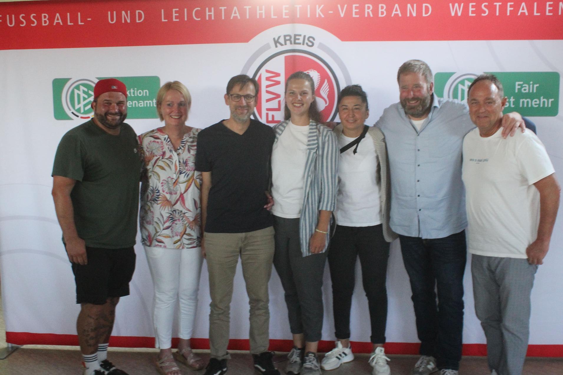 Gruppenfoto von sieben Personen vor einem Banner des Fu&szlig;ball- und Leichtathletik-Verbandes Westfalen e.V.