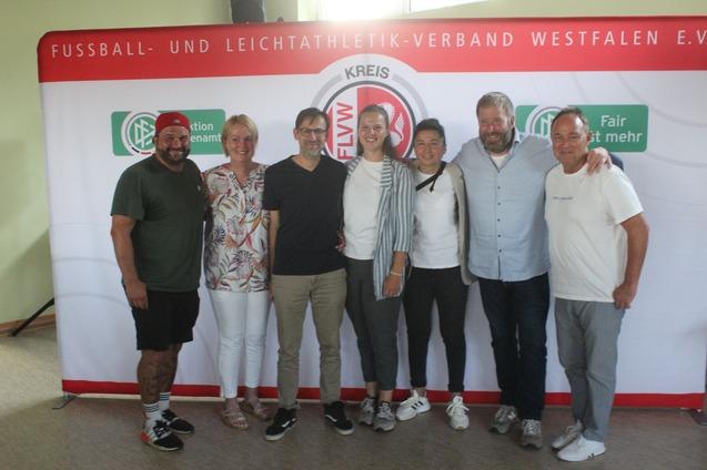 Gruppenfoto von sieben Personen vor einem Banner des Fu&szlig;ball- und Leichtathletik-Verbandes Westfalen e.V.