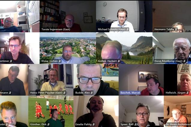 Videokonferenz mit mehreren Teilnehmern, die auf einem Raster-Hintergrund zu sehen sind, einige in kleineren Fenstern.