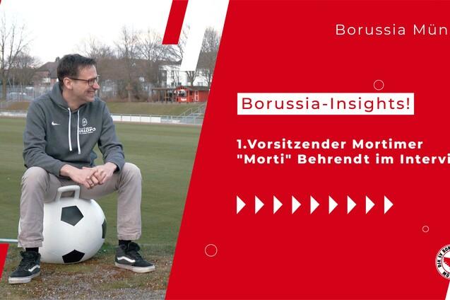 1. Vorsitzender Mortimer Behrendt sitzt auf einem Fu&szlig;ball in einem Interview auf dem Rasenplatz von Borussia M&uuml;nster.