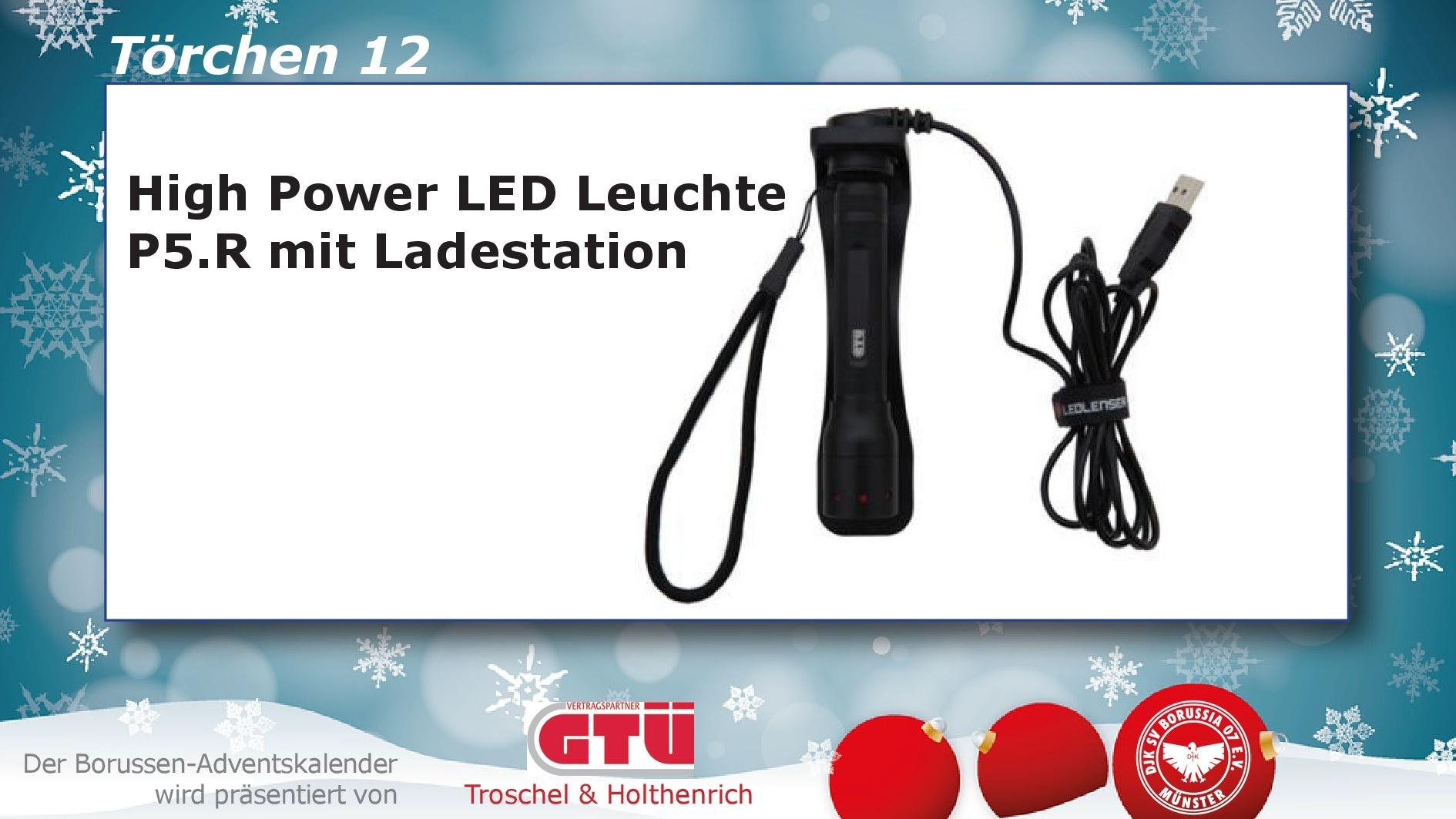 High Power LED Leuchte P5.R mit Ladekabel auf einem weißen Hintergrund, umgeben von festlicher Dekoration.