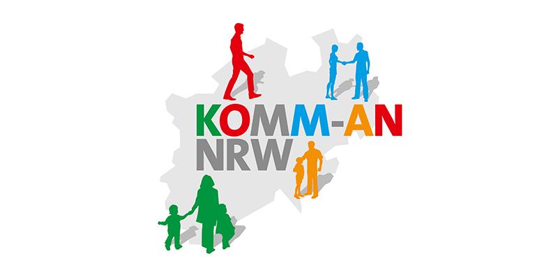 Grafische Darstellung des Schriftzugs "KOMM-AN NRW" mit stilisierten Figuren in verschiedenen Farben auf einer grauen Karte.