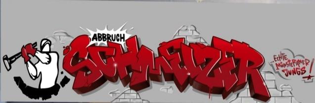 Graffiti mit der Aufschrift &bdquo;Abbruch Schweitzer&ldquo; in roten Buchstaben, erg&auml;nzt durch eine ikonische Figur mit Hammer.